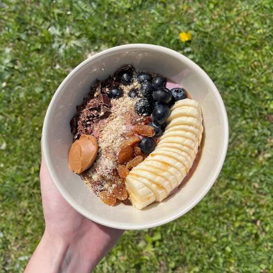 Fresh smoothie bowl with berries, banana, chocolate and peanut butter